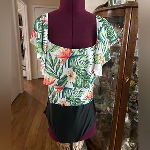 One Piece Bathing Suit With Tropical Design. Ruffled Neckline.